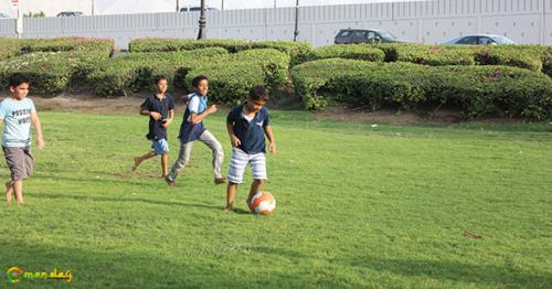 Kids dribble a football in a lawn in Azaiba. (Right) A wadi being used as a football ground.
